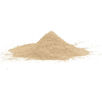 El polvo de cemento de resina de color beige pálido forma una pequeña pila cónica sobre una superficie blanca y lisa.
