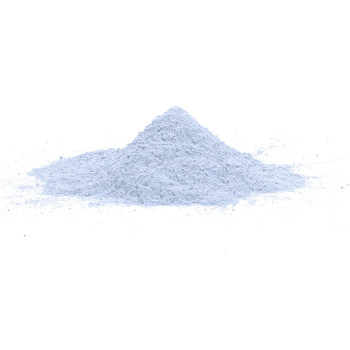 Una pequeña pila cónica de polvo fino de color azul claro se asienta sobre una superficie blanca y lisa, sobre un fondo blanco l