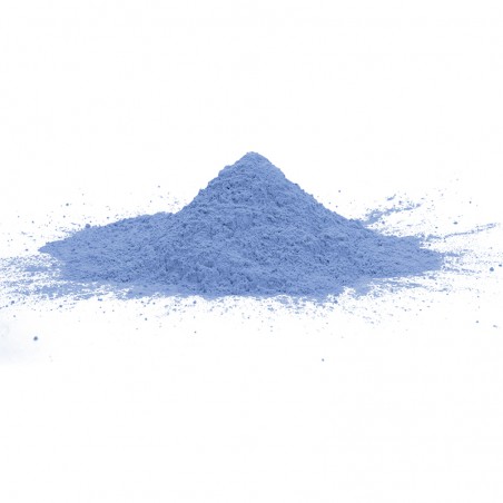 Un montículo cónico de polvo azul claro descansa sobre una superficie blanca y se extiende ligeramente hacia afuera en la base.