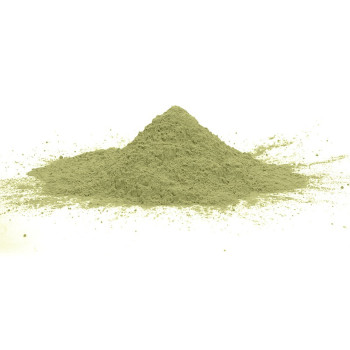 Polvo verde que forma un pequeño montículo, apoyado sobre una superficie plana y blanca, con finas partículas dispersas a su alr