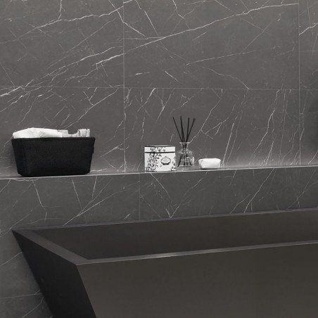 Una bañera rectangular negra se apoya contra paredes de mármol gris. arriba, un estante sostiene una canasta con toallas, una ca Una bañera rectangular negra se apoya contra paredes de mármol gris. arriba, un estante sostiene una canasta con toallas, una ca
