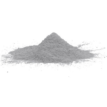 Un petit monticule de poudre fine et grise repose sur une surface blanche et unie, suggérant un matériau utilisé pour la constru