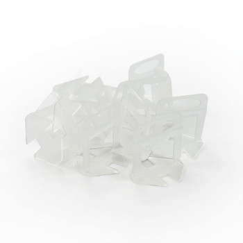 Clipes transparentes para sacos plásticos estão espalhados aleatoriamente sobre um fundo branco liso, formando uma pilha frouxam