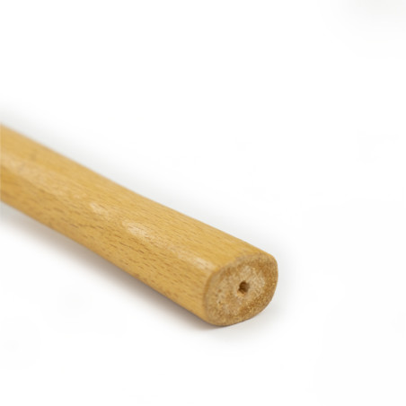 Een houten stok rust op een witte achtergrond, heeft een gladde cilindrische vorm en een klein gaatje aan het zichtbare uiteinde
