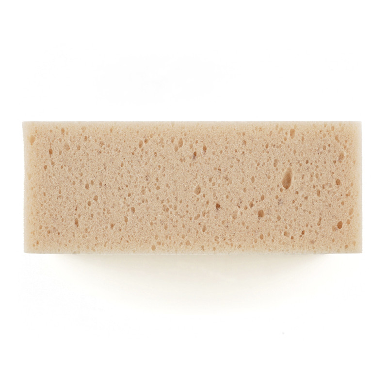 Uma esponja retangular bege com textura porosa assenta sobre um fundo branco liso.