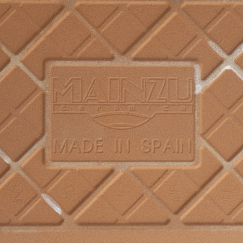 Um ladrilho cerâmico texturizado apresenta um padrão de diamante. O relevo central diz: `MAINZU ceramica MADE IN SPAIN.` O conte