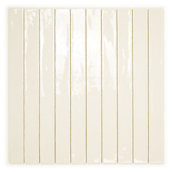 Un carreau de céramique étroit de couleur crème repose verticalement sur un fond blanc, réfléchissant subtilement la lumière sur