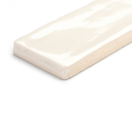 Eine rechteckige Keramikfliese liegt flach und zeigt eine glänzende cremefarbene Oberfläche mit weichen, wellenförmigen Mustern. Eine rechteckige Keramikfliese liegt flach und zeigt eine glänzende cremefarbene Oberfläche mit weichen, wellenförmigen Mustern.