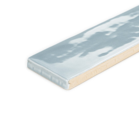 Ladrilho retangular com superfície azul clara brilhante e textura subtil ondulada, sobre fundo branco liso.