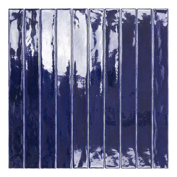 Een lange, smalle, glanzende marineblauwe tegel staat verticaal en reflecteert licht, gepositioneerd tegen een effen witte achte