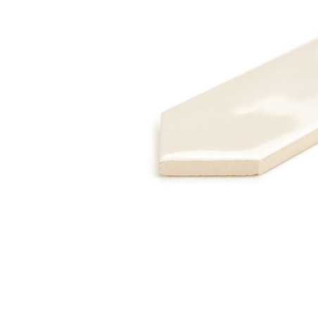 Un carreau brillant blanc cassé aux bords pointus repose sur une surface blanche, réfléchissant subtilement la lumière dans un d Un carreau brillant blanc cassé aux bords pointus repose sur une surface blanche, réfléchissant subtilement la lumière dans un d