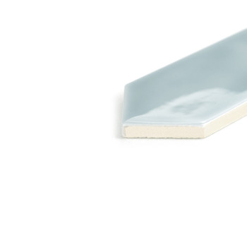 Un carreau mince et brillant bleu clair avec un bord biseauté repose sur une surface blanche, mettant en valeur son coin unique.
