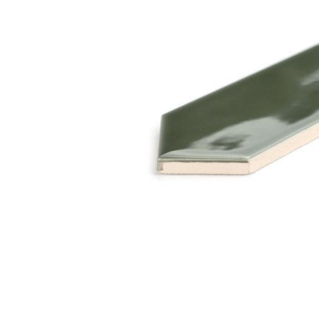 Um ladrilho cerâmico verde alongado e brilhante fica inclinado sobre um fundo branco e limpo, revelando sua extremidade cônica e