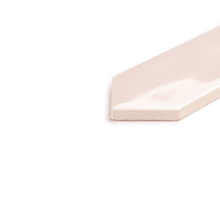 Un carreau de céramique brillant rose clair repose à plat, affichant une finition polie. Il est placé sur un fond blanc uni.