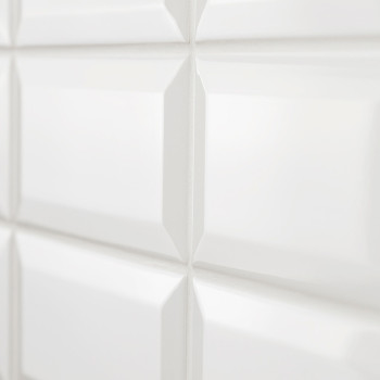 Los azulejos cerámicos blancas brillantes forman un patrón de cuadrícula que refleja la luz y crea una apariencia limpia y moder