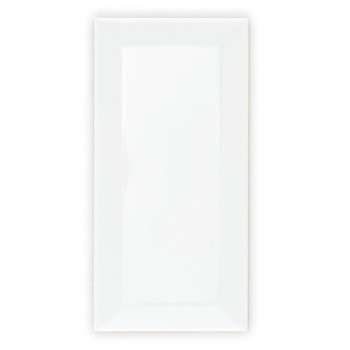 Un carreau blanc brillant et rectangulaire aux bords biseautés repose sur un fond blanc uni, reflétant une douce lumière ambiant