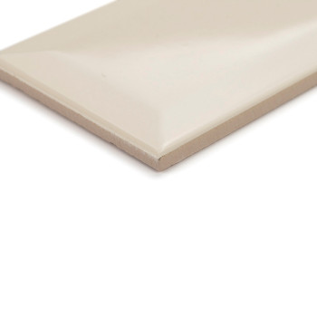 A rectangular, beige ceramic tile lies flat, showing smooth, glossy surface and chamfered edges, suitable for wall or floor inst