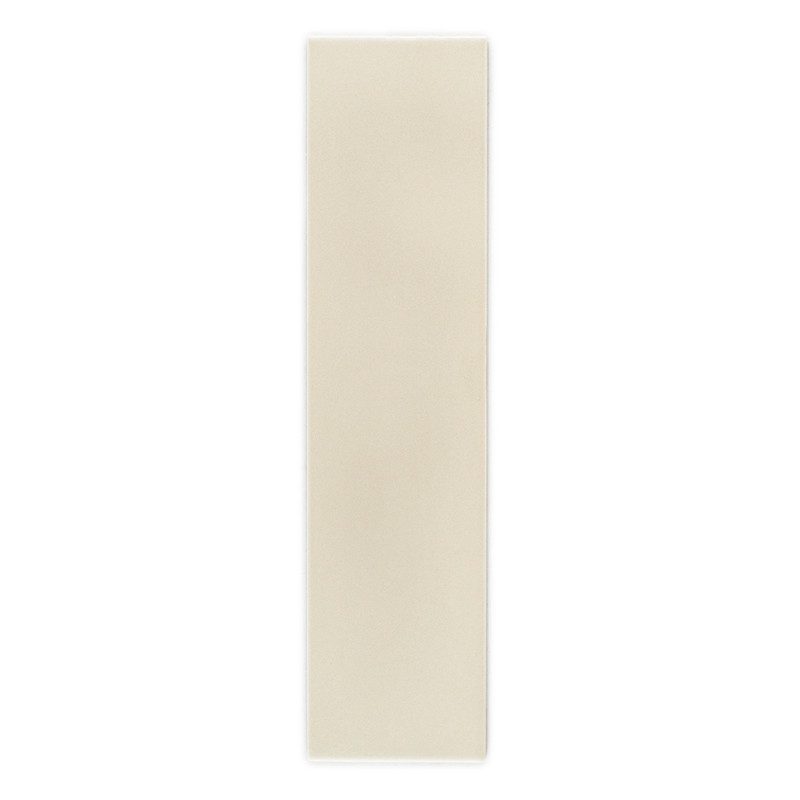 Un mosaico largo y rectangular de color beige descansa verticalmente sobre un fondo blanco, mostrando su superficie lisa y unifo