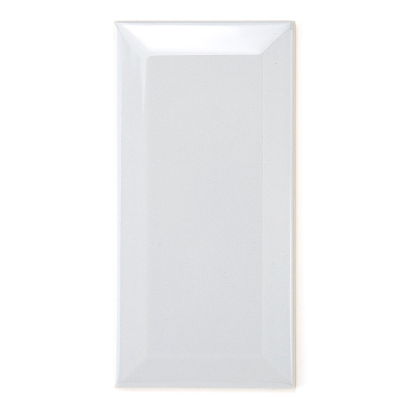 Um ladrilho retangular branco brilhante reflete a luz, enfatizando sua superfície lisa, com bordas levemente chanfradas, contra 