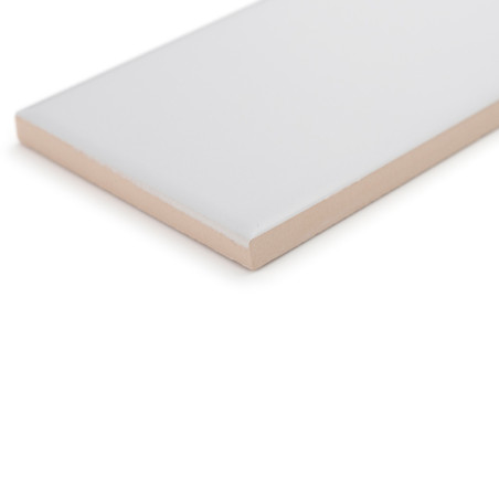 Un carreau de céramique rectangulaire repose sur une surface blanche, mettant en valeur un dessus blanc lisse et brillant et un 
