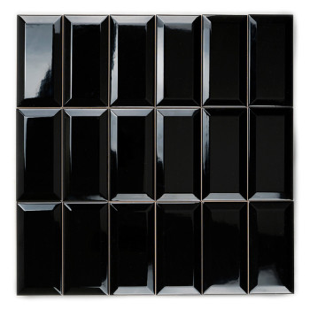 Un carreau de céramique noir rectangulaire et brillant repose debout sur un fond blanc, réfléchissant la lumière sur sa surface 