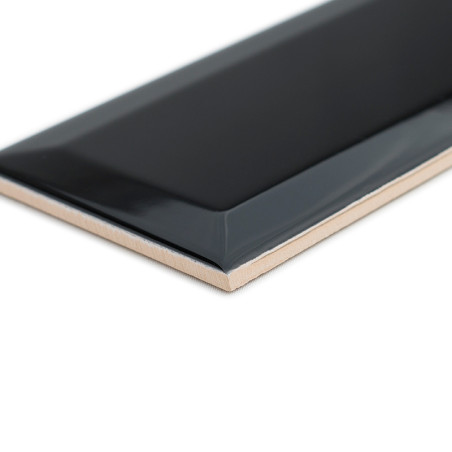 Un azulejo rectangular negro brillante con bordes biselados se encuentra en ángulo, mostrando su superficie lisa que contrasta c Un azulejo rectangular negro brillante con bordes biselados se encuentra en ángulo, mostrando su superficie lisa que contrasta c