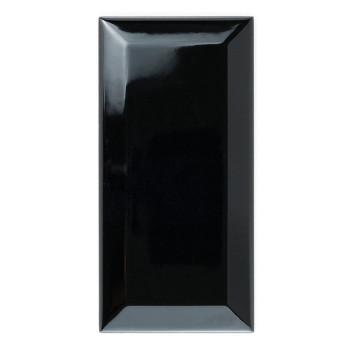 Un carreau de céramique noir rectangulaire et brillant repose debout sur un fond blanc, réfléchissant la lumière sur sa surface 