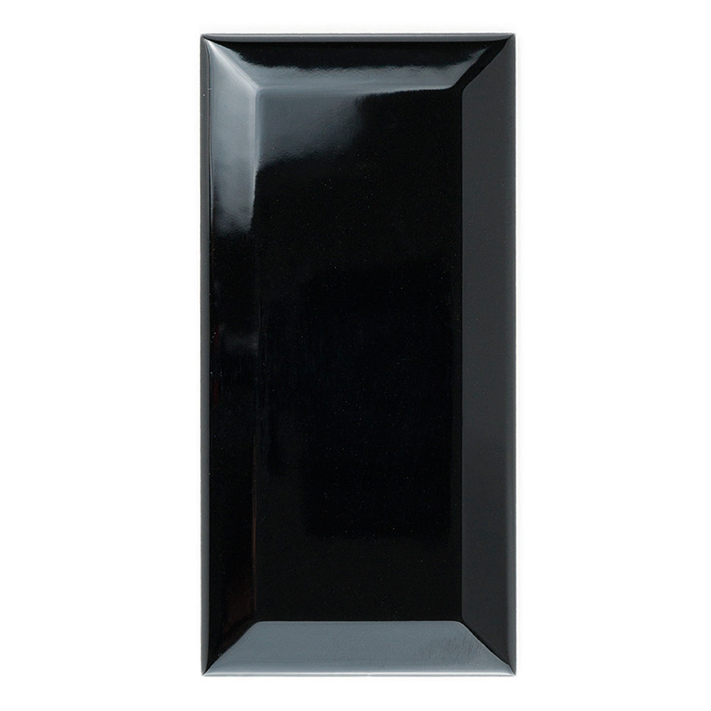 Una losa de cerámica negra rectangular y brillante se apoya en posición vertical sobre un fondo blanco, reflejando la luz en su 