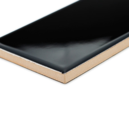 Un carreau de céramique noir brillant présente son bord angulaire exposé, mettant en valeur sa surface lisse sur un fond blanc u Un carreau de céramique noir brillant présente son bord angulaire exposé, mettant en valeur sa surface lisse sur un fond blanc u