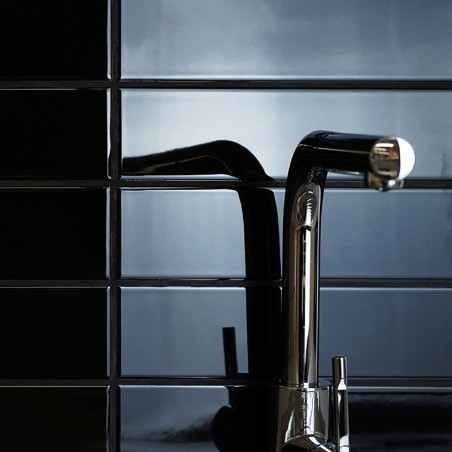 Uma elegante torneira cromada se estende horizontalmente, refletindo a luz contra uma parede de azulejos pretos brilhantes, cria Uma elegante torneira cromada se estende horizontalmente, refletindo a luz contra uma parede de azulejos pretos brilhantes, cria