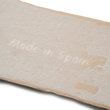 Carreau rectangulaire blanc cassé avec une surface texturée. Le texte « Made in Spain » est subtilement gravé au centre des carr