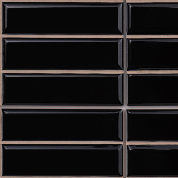 Los azulejos rectangulares negros están dispuestos en una cuadrícula, separados por líneas de lechada de color beige, creando un