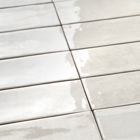 Los azulejos cerámicos rectangulares están dispuestas en una cuadrícula, reflejando la luz, creando una superficie brillante y c