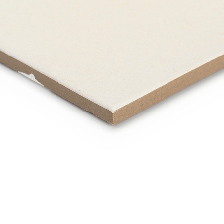 Un azulejo cerámico rectangular yace plana, mostrando su superficie lisa de color crema y sus bordes ligeramente biselados sobre