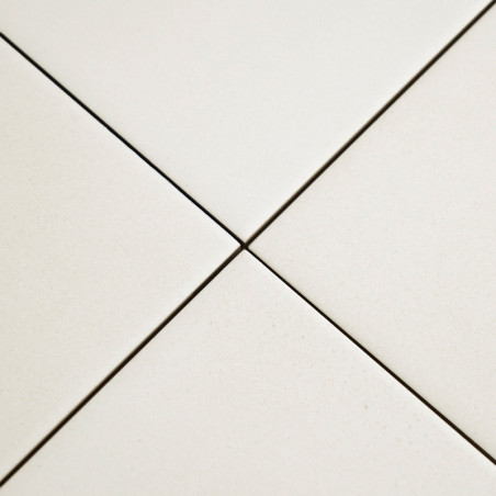 Quatro ladrilhos cerâmicos brancos se encontram em um ponto central, formando um formato positivo com linhas estreitas de rejunt