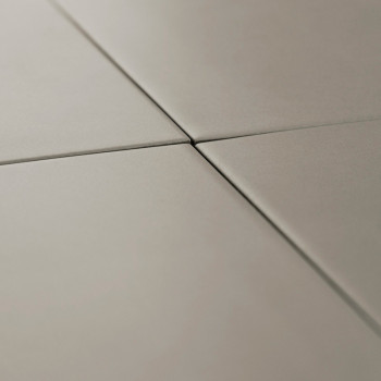 Quatre carreaux lisses, carrés et mats se rejoignent au centre, formant des lignes droites précises dans un décor intérieur mini