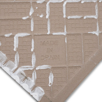 Un carreau de céramique carré avec un motif quadrillé beige présente le texte « MADE IN SPAIN » en relief sur sa surface, entour