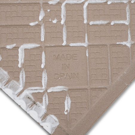 Un carreau de céramique carré avec un motif quadrillé beige présente le texte « MADE IN SPAIN » en relief sur sa surface, entour