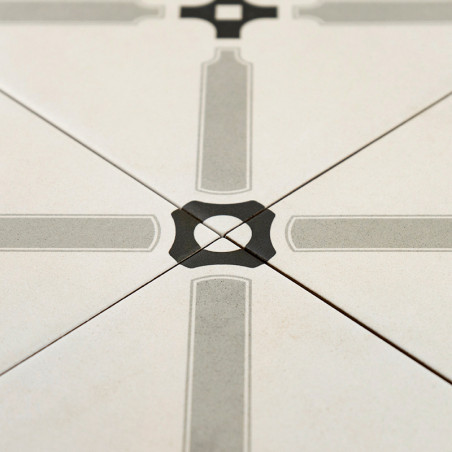 A ceramic tile features a symmetrical geometric pattern with intersecting grey lines forming a cross, centered by a black diamon