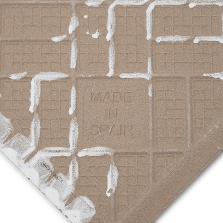 Un azulejo beige con la leyenda `MADE IN SPAIN` impreso y presenta un patrón de cuadrícula tipo gofre. Un residuo blanco texturi Un azulejo beige con la leyenda `MADE IN SPAIN` impreso y presenta un patrón de cuadrícula tipo gofre. Un residuo blanco texturi