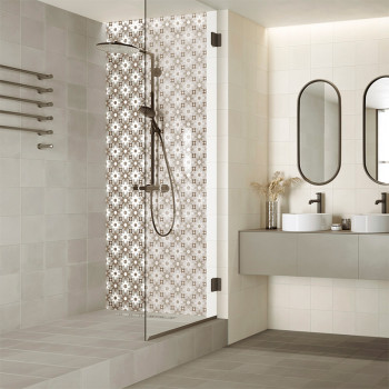 Un espace douche avec des carreaux à motifs comprend une pomme de douche en métal sombre. C'est dans une salle de bains moderne 