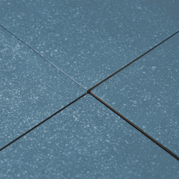 Blaue Keramikfliesen sind in einem Gittermuster angeordnet, hervorgehoben durch subtile gesprenkelte Texturen, mit minimaler Fug