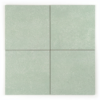 Un carreau carré affiche une texture mouchetée subtile, avec une teinte vert tendre, créant une apparence neutre et apaisante.