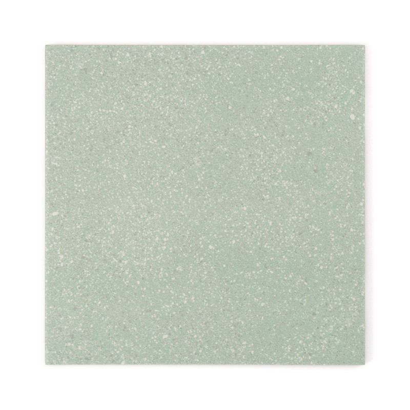 A square tile displays a subtle speckled texture, featuring a soft green hue, creating a neutral and calming appearance.