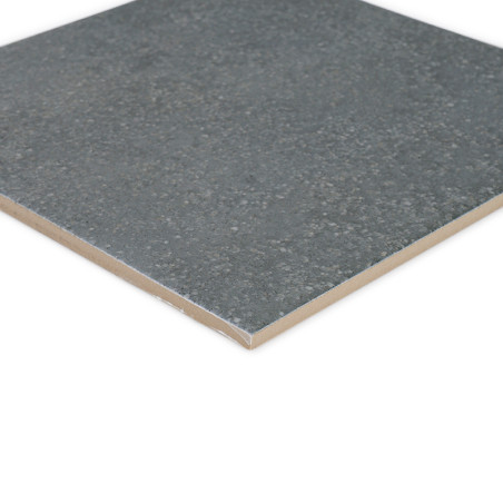 A square, gray ceramic tile lies flat, showing a textured, speckled surface with a smooth edge, suitable for flooring or walls.