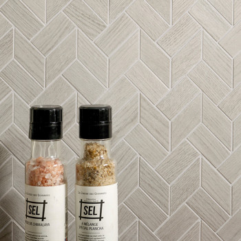 Two spice bottles stand against a light gray herringbone tile wall. Text on the bottles reads `SEL,` `SEL DE HIMALAYA,` and `MÉL
