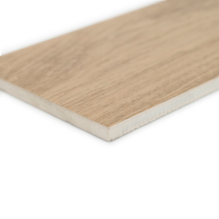 Un azulejo rectangular con textura de madera y acabado marrón claro descansa sobre un fondo blanco, mostrando su superficie plan
