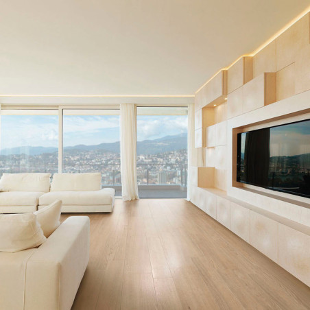 Una amplia sala de estar cuenta con un televisor grande en un moderno mueble de pared de madera, con sofás blancos que ofrecen v