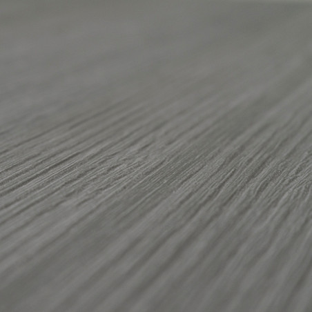 Un primer plano de una superficie texturizada de color gris con ranuras paralelas que corren en diagonal, asemejándose a la veta