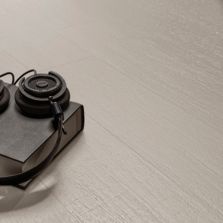 Los auriculares descansan sobre un libro negro cerrado, colocado sobre un piso o Azulejo texturizada de color claro, creando un 